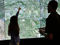 Click to see an image of UTM team members in front of the UTM simulation displays