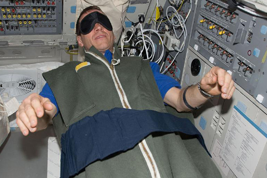 Image of an astronaut sleeping on the International Space Station